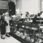 Two women in jackets and hats at the counter of Reynolds Candy Shop