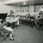 A group of students in a room learning to sew
